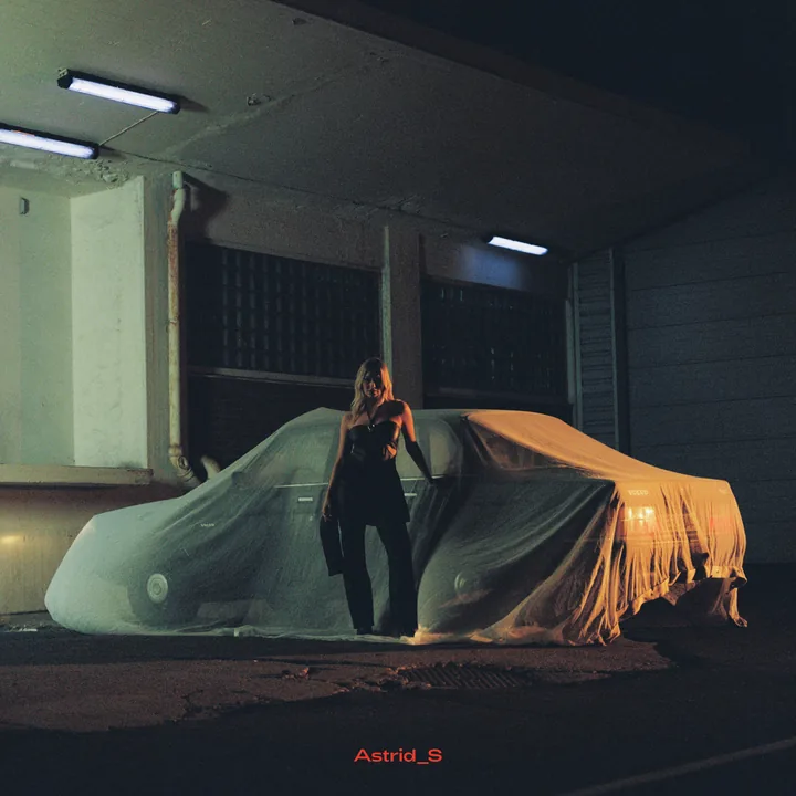 Astrid S sitt albumomslag med artisten foran to tildekkede biler