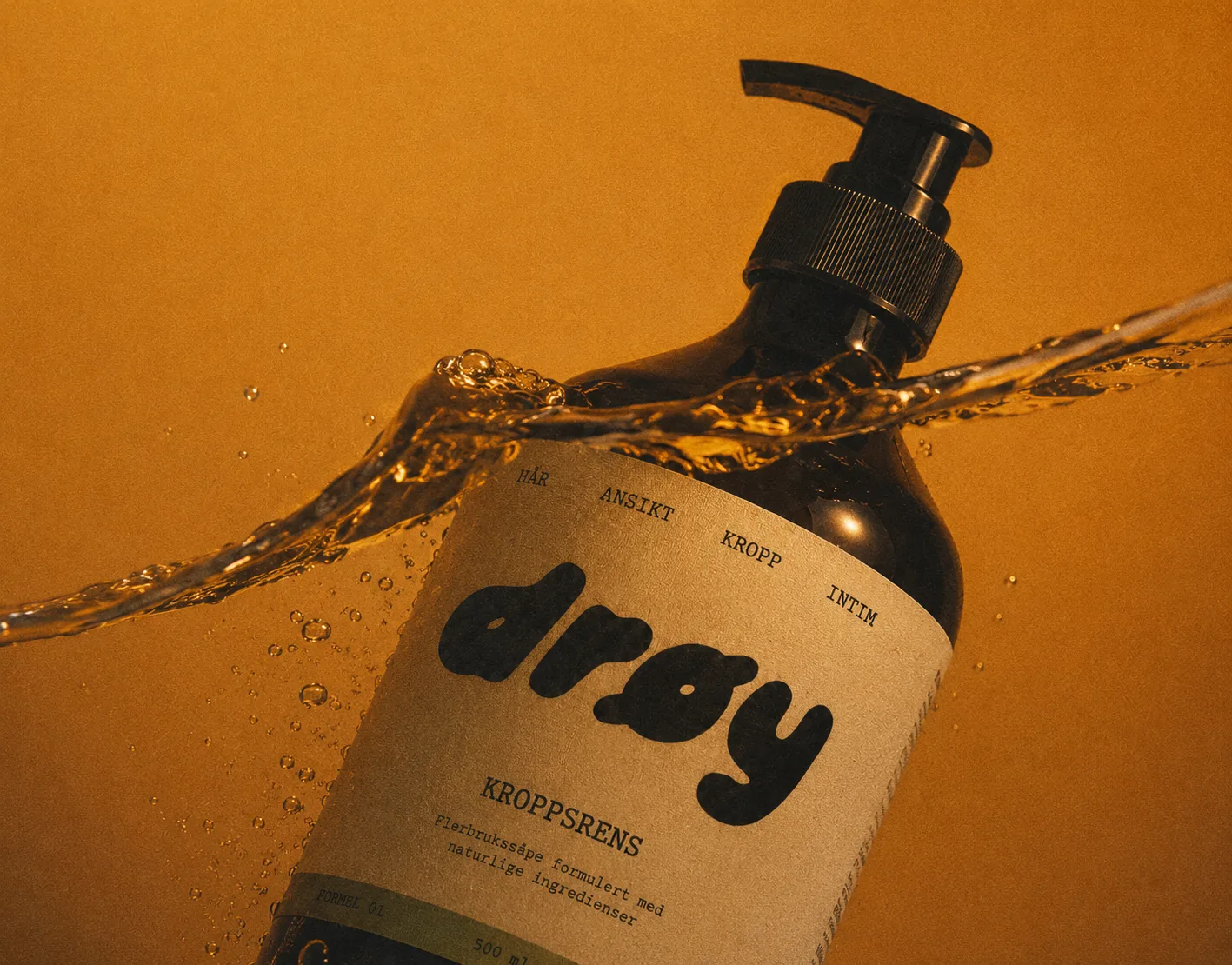 Flasken med DRØY kroppsrens i en sprut av vann